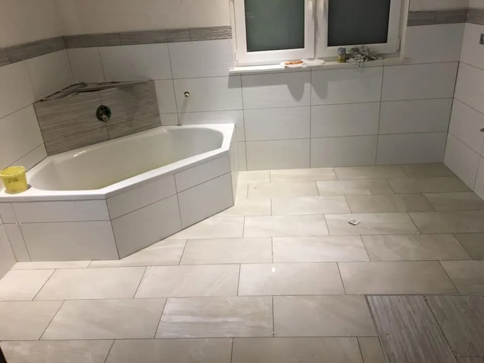 Saniertes Bad mit Eckbadewanne, großformatigen Wand- und Bodenfliesen