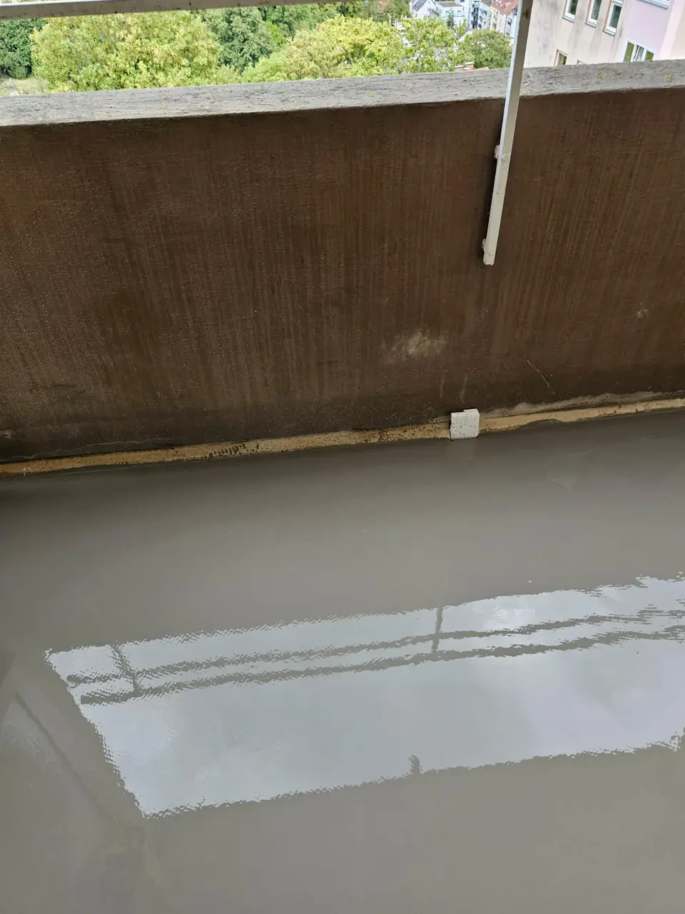 Frisch aufgebrachte Ausgleichsmasse auf einem Balkon