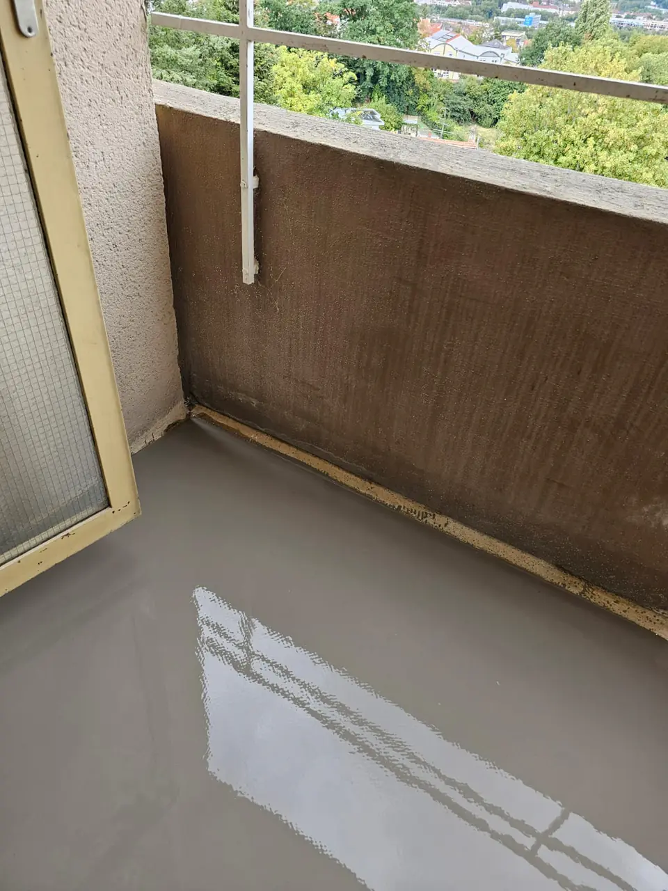 Egalisierter Balkonboden, im Hintergrund Bäume und Häuser