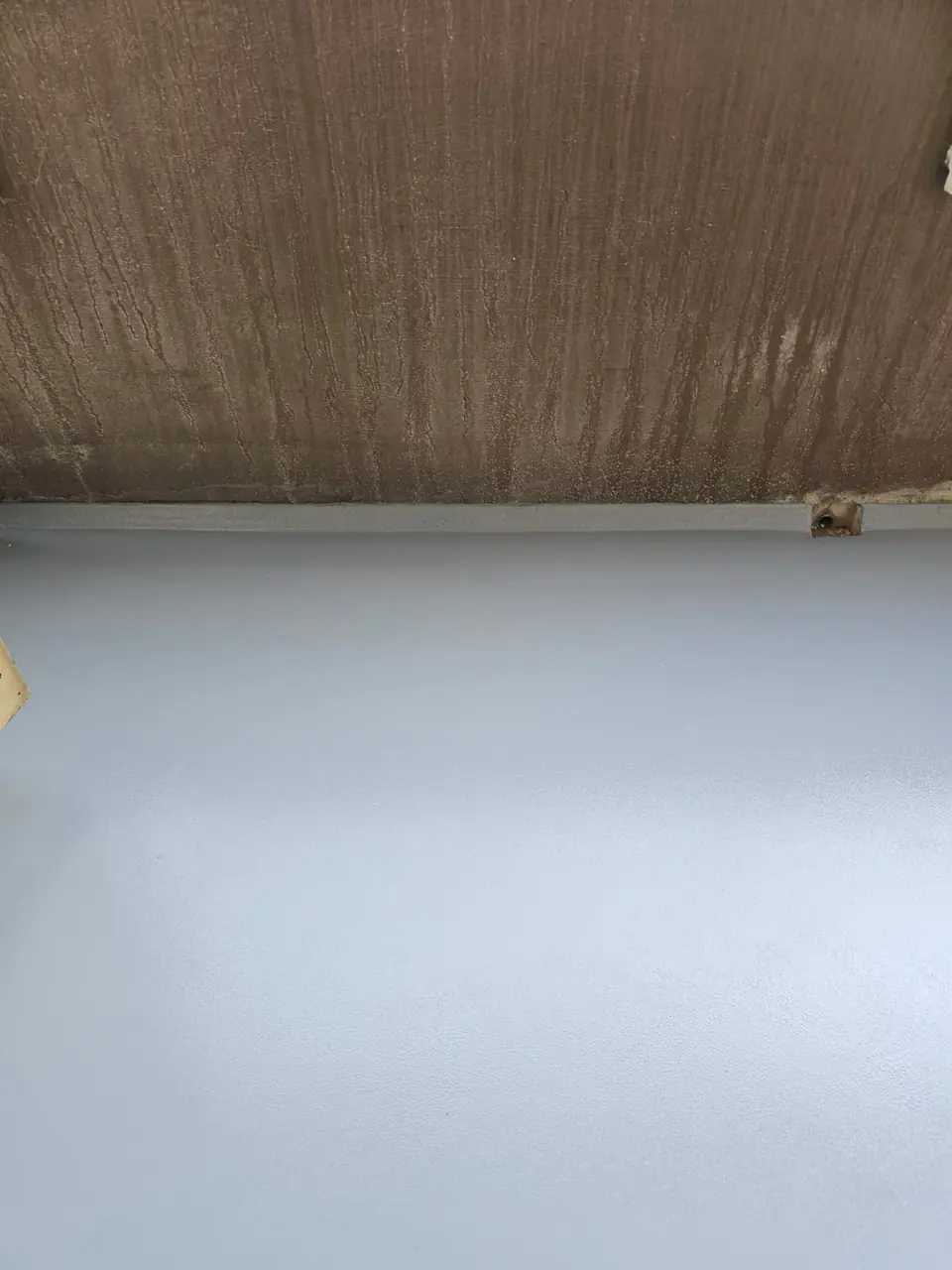 Graue Bodenbeschichtung auf einem sanierten Balkon