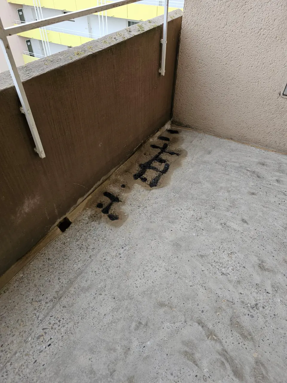 Balkon vor der Sanierung: Betonboden mit alten Flickstellen