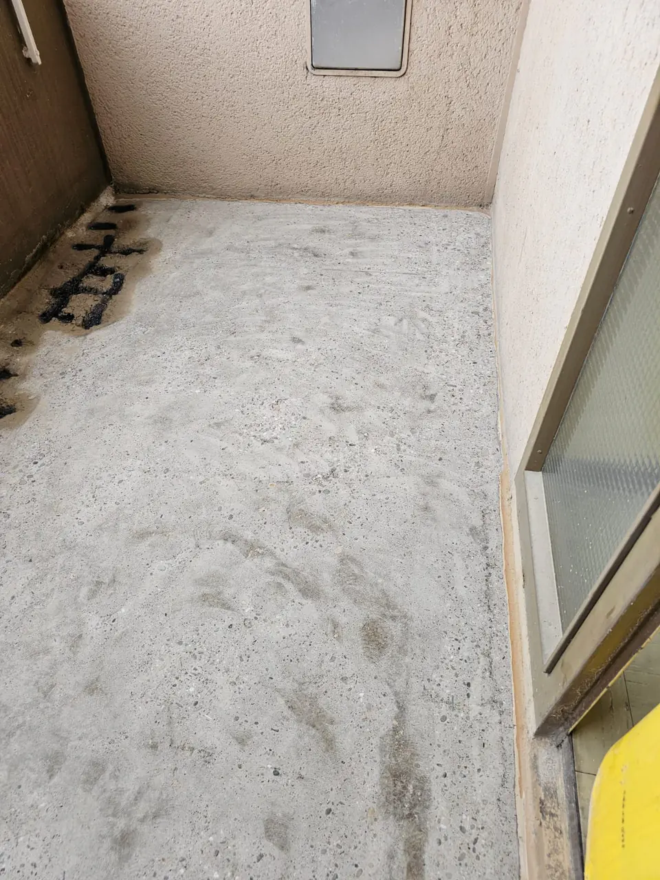 Balkonboden vor der Sanierung mit Flickstellen an der Brüstung
