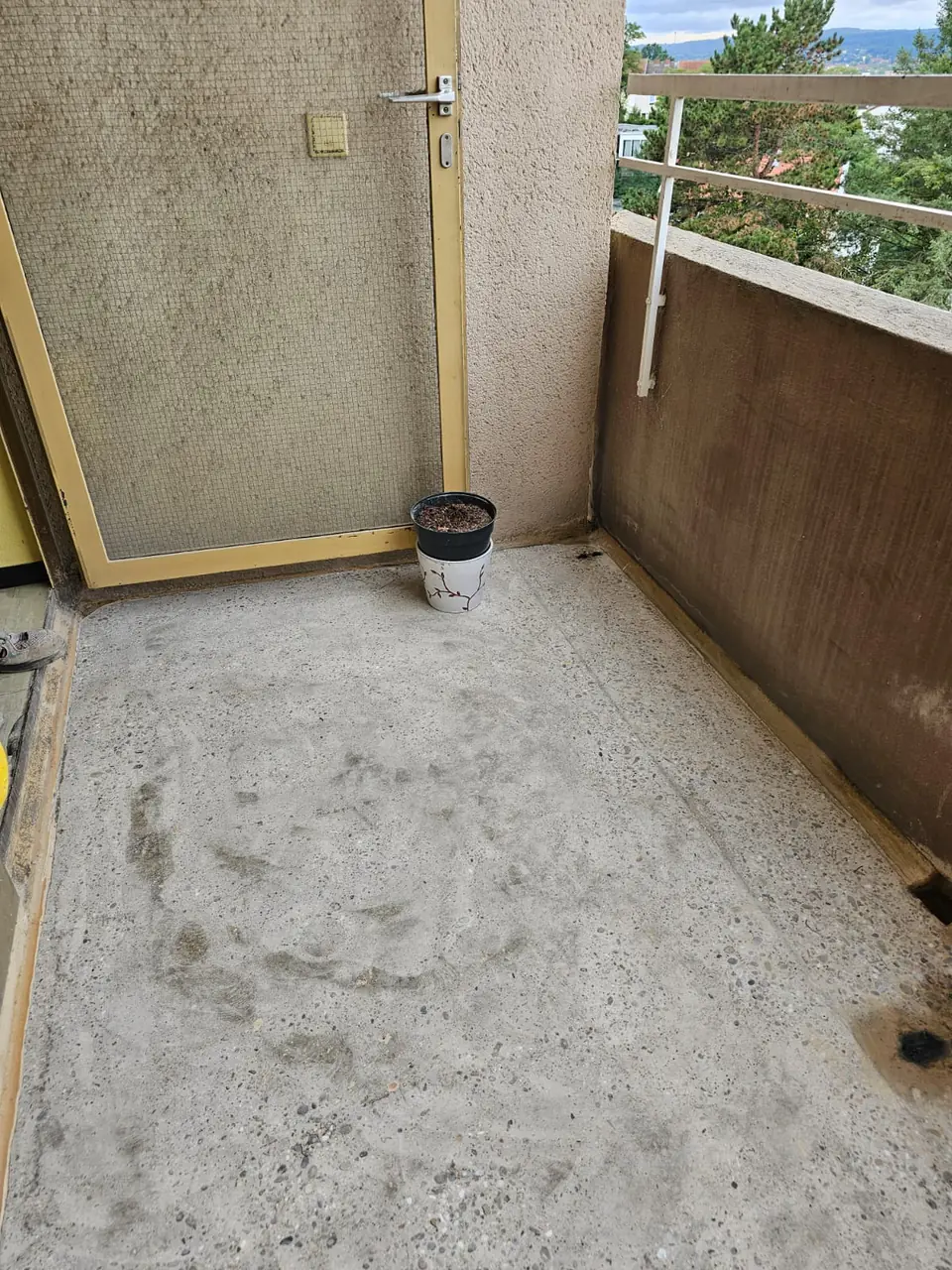 Balkon mit Betonboden und Balkontür vor der Sanierung