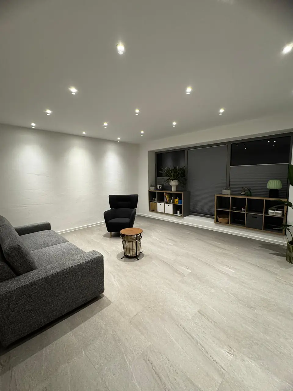 Sitzbereich mit LED-Einbaustrahlern in der Decke und hellem Bodenbelag in Steinoptik