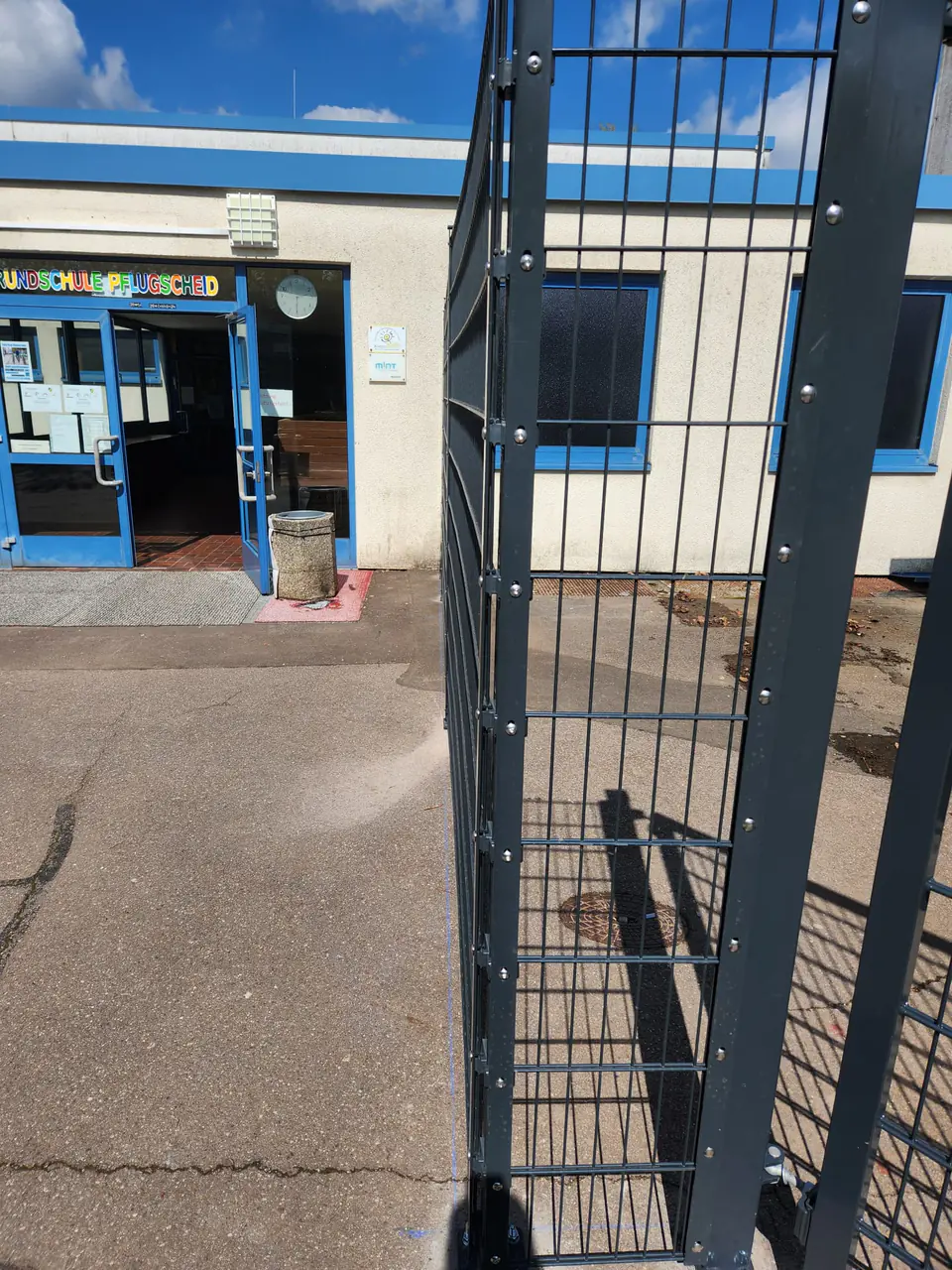Eingang der Grundschule Pflugscheid mit angrenzender Zaunanlage